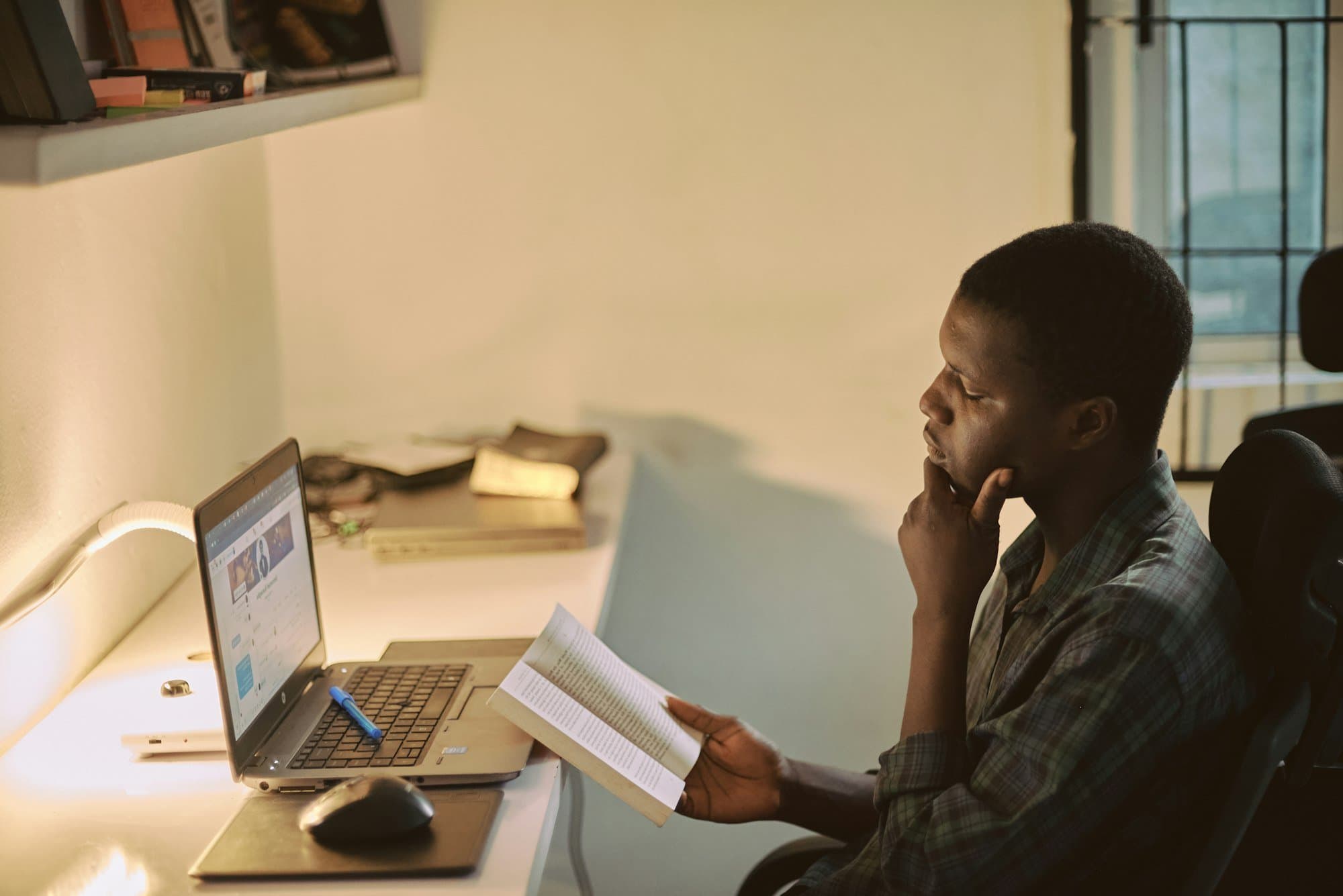 A lawyer reading a legal text beside a laptop